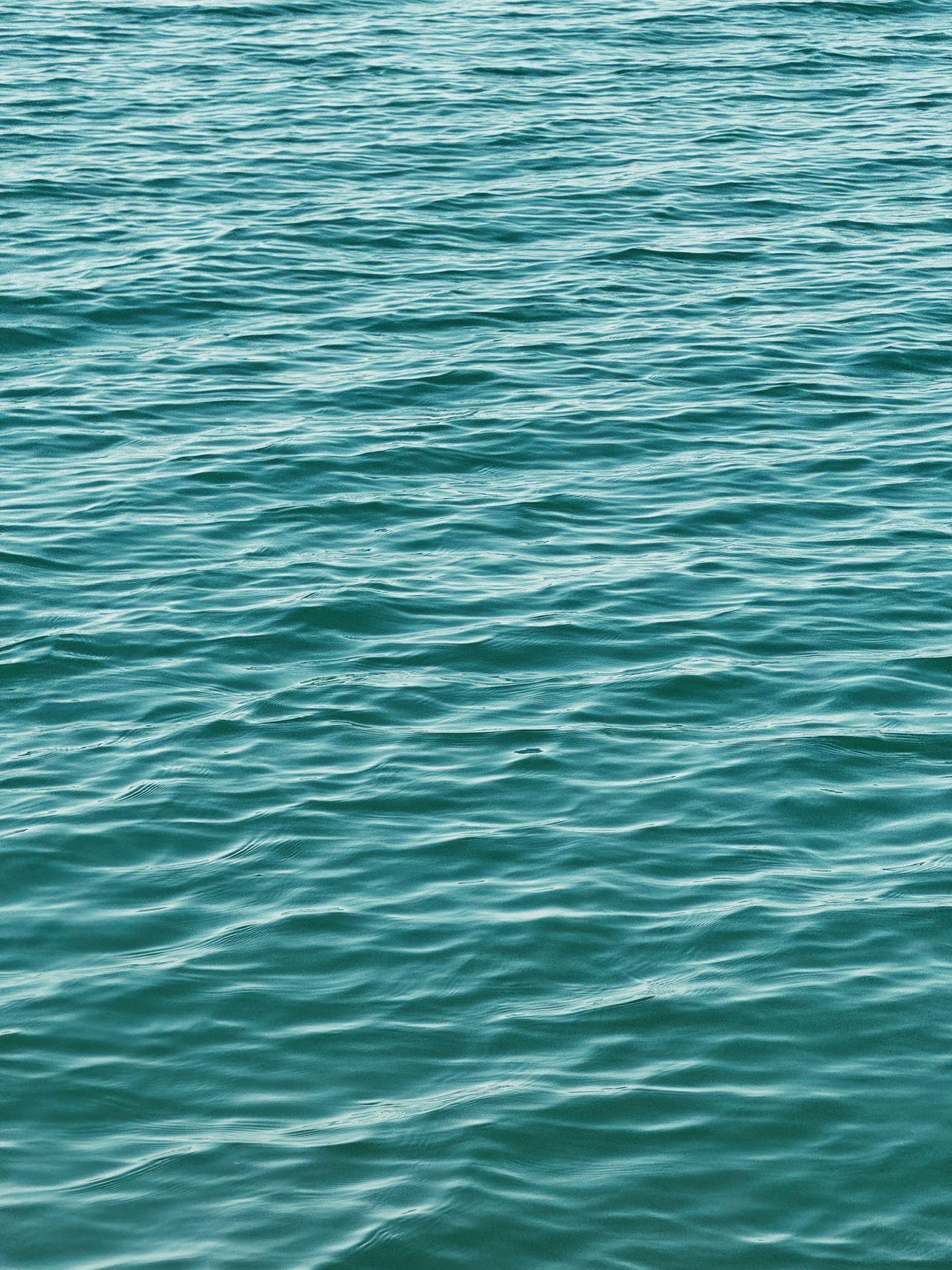 Gentle turquoise wave patterns across the water's surface